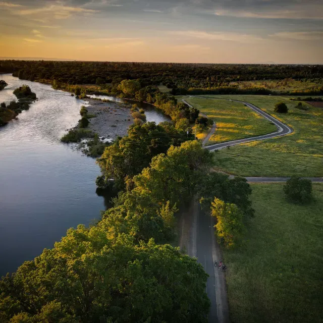 Image of green area and waterway next to it during sun set 